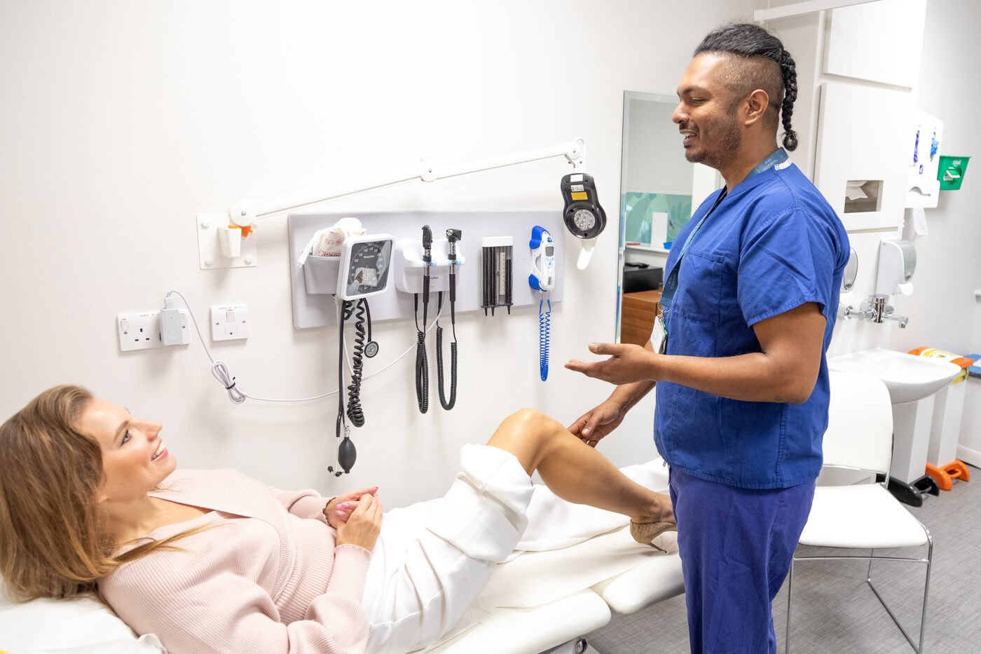Dr Arj Imbuldeniya examining a patient's knee during a cartilage repair consultation